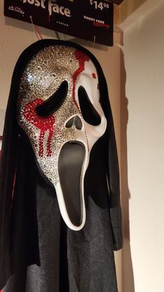 a mask hanging on the wall with its mouth open and blood dripping out from it