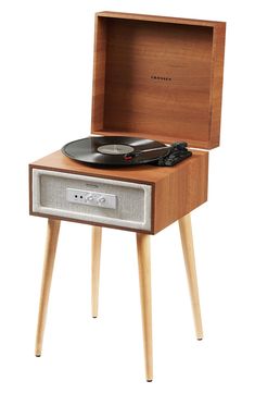 an old record player is sitting on a wooden stand