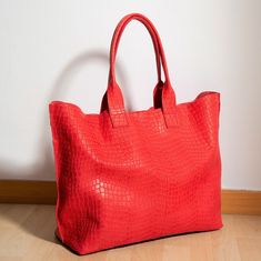 Red leather tote handmade in our workshop with natural cow leather and a crocodile-embossed effect. The intense red color makes it a perfect gift. This roomy carry-all tote is the ideal companion for your everyday activities, and it also works as a weekender bag for a short outing. With its large capacity, this purse can carry all your essentials: books, wallet, phone, makeup pouch, sunglasses, clothing, and more. The inside canvas bag fits a 15-inch laptop. Another feature of this handbag is th Croc Bag, Extra Large Tote Bags, Red Leather Bag, Red Leather Handbags, Large Leather Tote Bag, Sac Week End, Oversized Tote Bag, Oversized Tote, Large Leather Tote