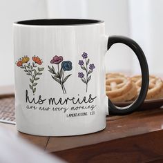 a coffee mug sitting on top of a wooden table next to some pretzels