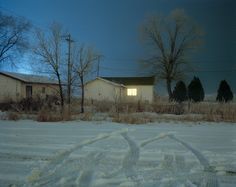 an image of a snow covered yard at night with the moon in the sky behind it