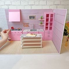 a dollhouse kitchen with pink furniture and accessories