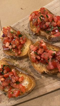 four pieces of bread with tomatoes and herbs on them