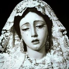 an old photo of a woman with tears on her face and veil over her head