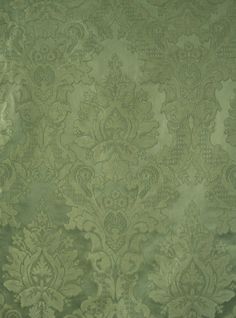 a green and gold wallpaper with an ornate design on it's surface,