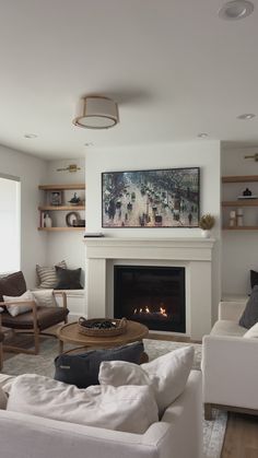 a living room filled with furniture and a fire place under a painting on the wall