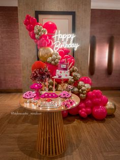 a birthday cake on a table surrounded by balloons