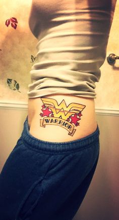 a woman's stomach with the word wonder tattooed on her lower back and side