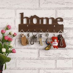 a bunch of key chains hanging on a wall next to a vase with flowers in it