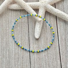 Dainty anklet with Blues and Yellow tiny crystal beads strung on a high quality latex free stretch cord. This dainty anklet looks great by itself or layered with another piece.  The anklet has no clasp, just slips over your fit and comfortably adjust to your ankle. You can choose your size from the dropdown menu. Please note: All jewelry is handmade with the Best quality materials, all our jewelry is delicate and needs to be handle with care.  OUR ENTIRE BRACELET COLLECTION  https://www.arieandc Blue Beaded Chain Anklets For Gift, Blue Beaded Chain Anklets As Gift, Blue Anklets With Tiny Beads, Adjustable Blue Anklets With Colorful Beads, Blue Anklets With Colorful Round Beads, Beads Anklet, Dainty Anklet, Morse Code Bracelet, Bracelet Minimalist