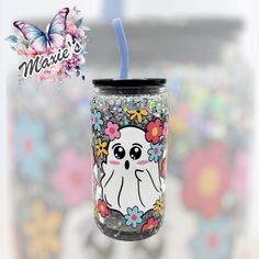 a glass with a straw in the shape of a cute little ghost and flowers on it