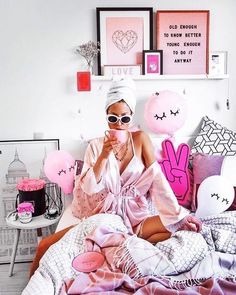 a woman sitting on top of a bed covered in pink and white sheets with bunny decorations