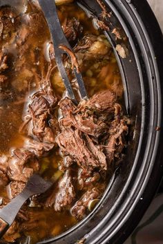 a slow cooker filled with shredded meat and vegetables, ready to be cooked in the crock pot