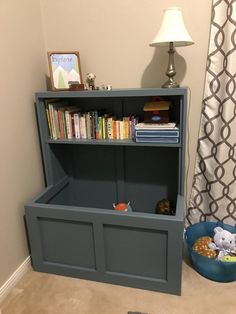 a bookshelf in the corner of a room next to a blue bowl and lamp