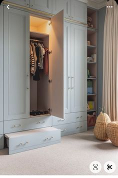 an open closet with clothes hanging on the doors and shoes sitting on the floor in front of it