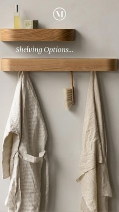 a wooden shelf with two towels hanging from it's sides and a brush on the wall