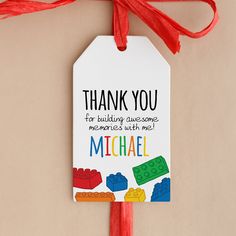 a thank you tag with legos on it hanging from a red tasseled ribbon