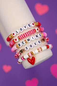 the stack of bracelets is decorated with hearts and words that spell out i love you