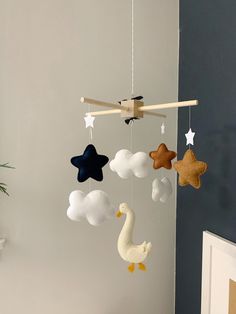 a crib mobile with stars, clouds and ducks hanging from it