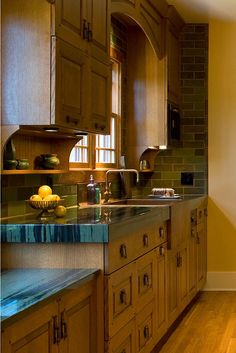 a kitchen with wooden cabinets and green counter tops