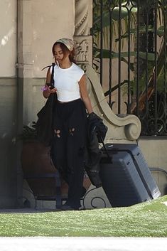 a woman in white shirt and black pants with luggage