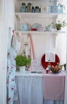 a shelf filled with dishes next to a table covered in plates and cups on top of it