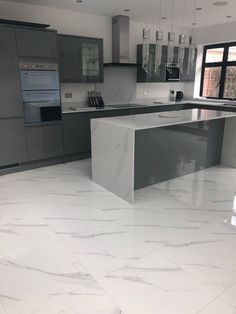 a modern kitchen with marble floors and stainless steel appliances