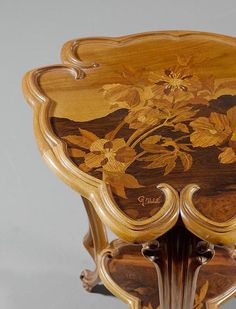 an ornately decorated wooden table with floral designs on the top and sides, inlaid with gold leaf accents