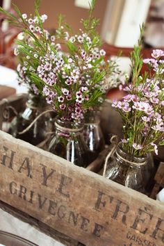 three mason jars filled with flowers sitting on top of a table