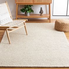 a living room area with a chair, table and rug on the floor in front of it