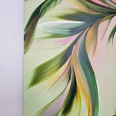 an abstract painting with green, yellow and pink colors on a white wall next to a vase