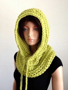 a female mannequin wearing a yellow knitted cowl with a hood on it