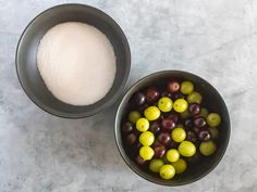 two bowls filled with different types of olives next to a bowl full of sugar