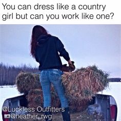 a woman standing on the back of a truck with hay in it's bed