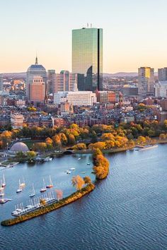 an aerial view of a city with boats on the water and trees in front of it