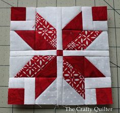 a red and white quilted block on the floor