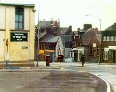 an old photo of a street corner with buildings in the background