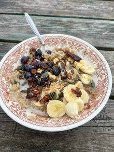 a bowl filled with oatmeal and fruit on top of a wooden table