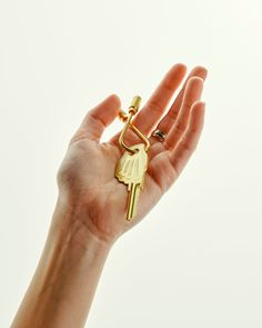 a person's hand holding a gold key to the sky