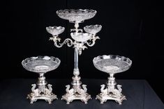 three silver candlesticks and one candle holder