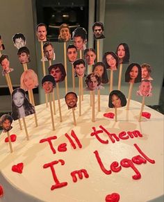 a white cake with red icing and pictures of people on it that says tell them i'm legal