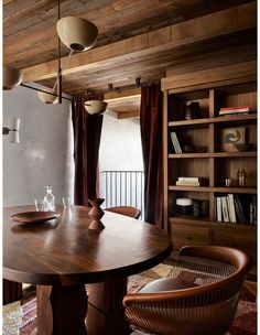 a dining room table and chairs in front of a bookshelf