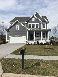 a gray house with white trim and two car garages in the front yard is shown