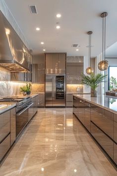 a modern kitchen with stainless steel appliances and marble counter tops, along with potted plants