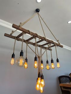 a chandelier made out of wood and light bulbs hanging from it's ceiling