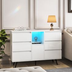 a white cabinet with a blue light in the middle and a lamp on top next to it