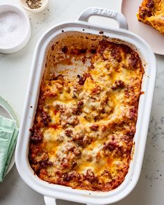 a casserole dish with meat and cheese in it on a white counter top