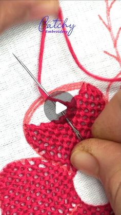 someone is working on a piece of fabric with scissors and yarn in the shape of an apple