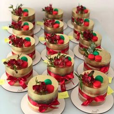 there are many small cakes with red flowers on each one and ribbons around the edges