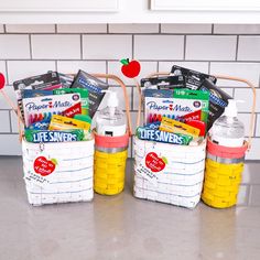 three baskets filled with school supplies sitting on top of a kitchen counter